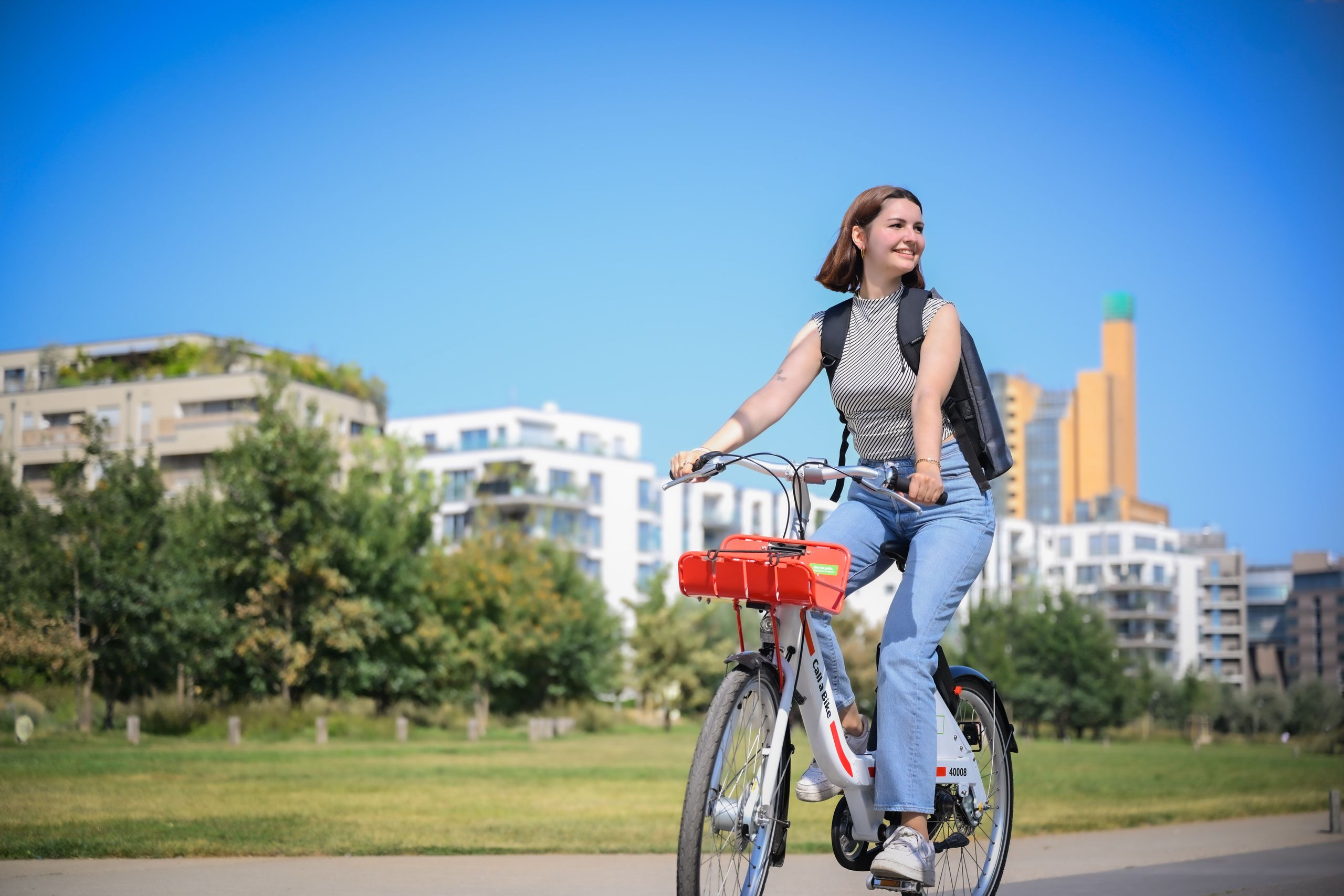 A woman is cycling on a Call a Bike through Gleisdreieck Park in Berlin.