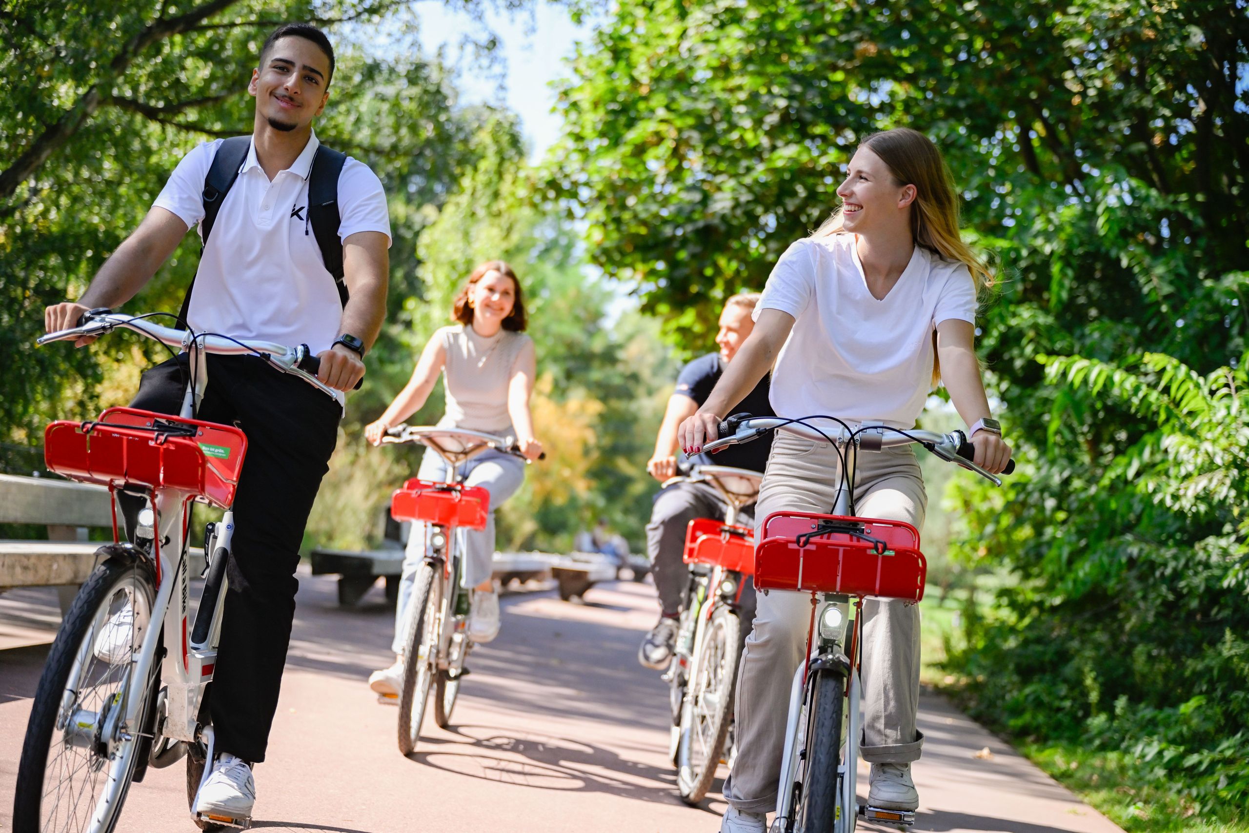 A group of people riding through a park with Call a Bike